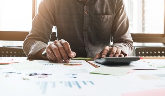 Man doing taxes using calculator