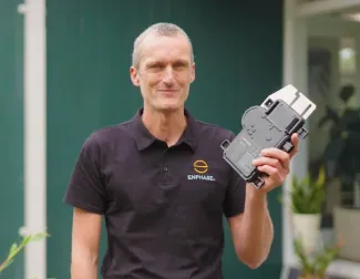 Solar installer holding Enphase mircoinverter