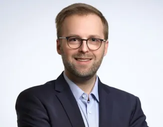 Headshot of man in blazer and button down shirt