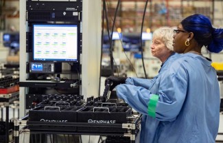 manufacturing employees inspecting microinverters