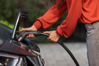 Woman plugging in Enphase EV Charger into electric vehicle 
