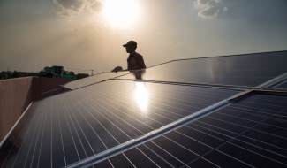Installer with solar panels on rooftop