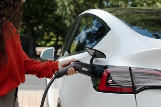 Woman charging Tesla model 3 with Enphase EV Charger