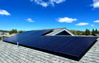 Roof with solar panels and blue sky in background