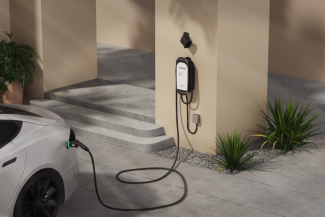 An electric vehicle parked in a garage, plugged into Enphase Level 2 EV charger