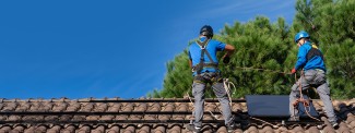 Solar installers on roof installing panels