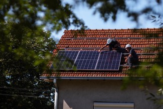 Solar installers mounting solar panels on a residential rooftop