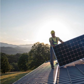 Solar installer on roof installing a solar panel