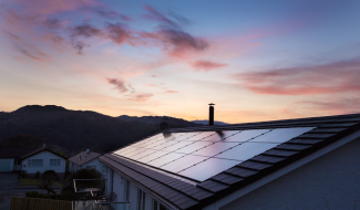 Rooftop solar panels basking in the golden hues of a sunset, showcasing renewable energy in action.
