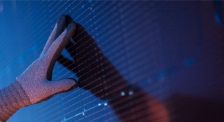  A gloved individual touching a solar panel.