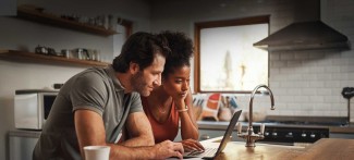 Man and woman at home looking at the computer screen