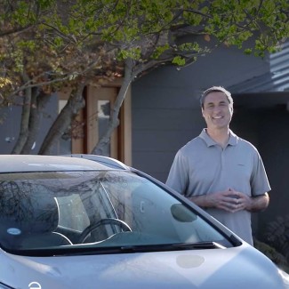 Photo of a man outside behind a car