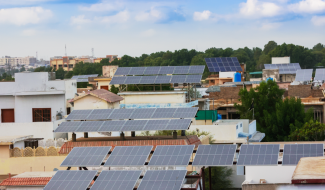Rooftop solar panels installed on residential buildings in an Indian neighborhood, showcasing the growing adoption of solar energy.
