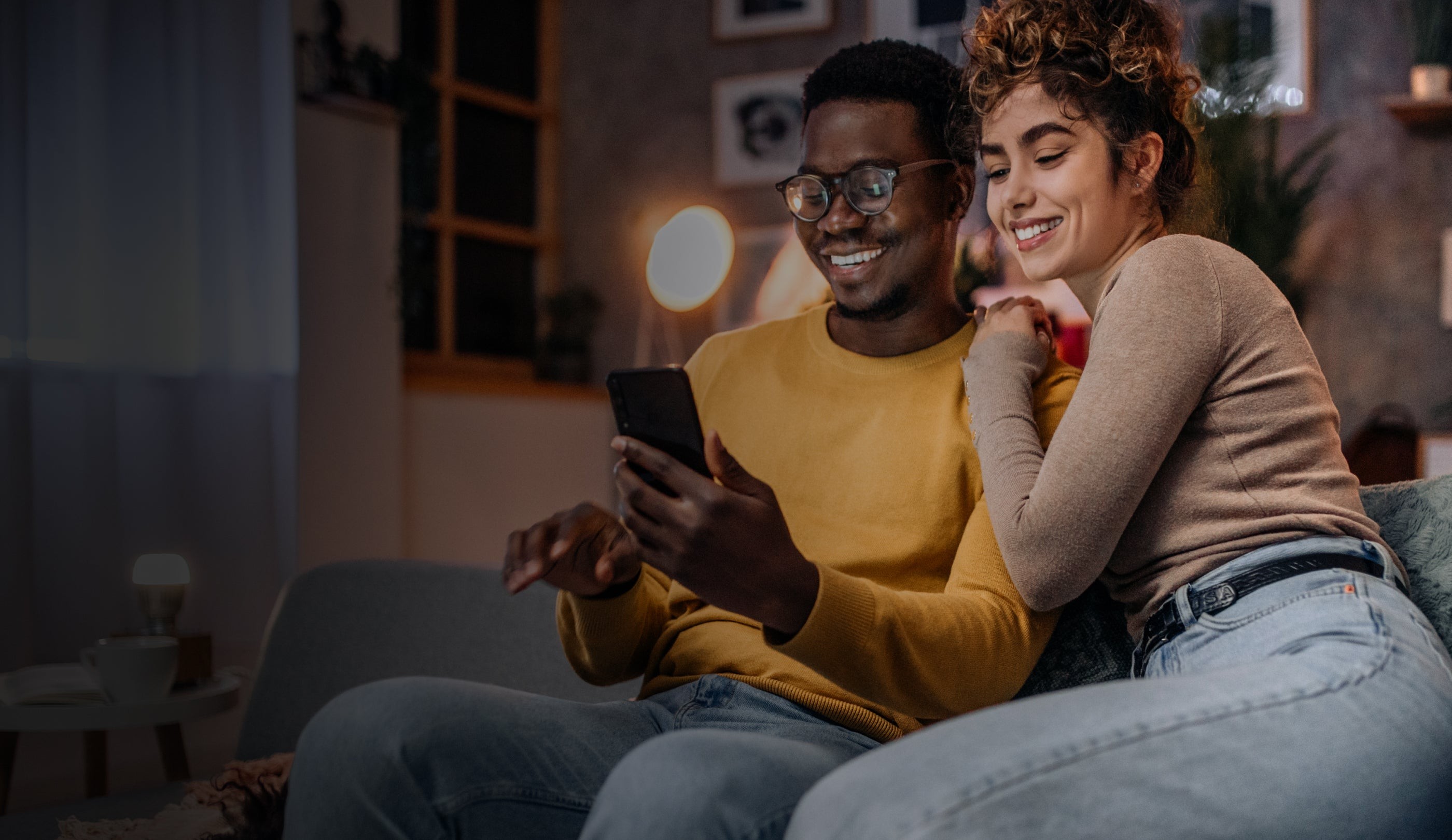 Couple in sofa looking at phone